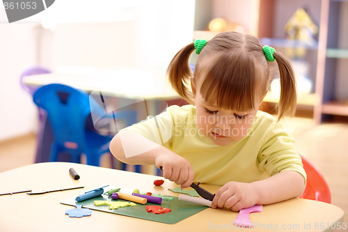 Image of Little girl play with plasticine in preschool