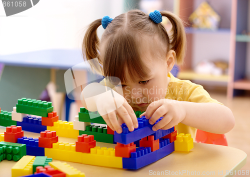 Image of Little girl play with building bricks in preschool