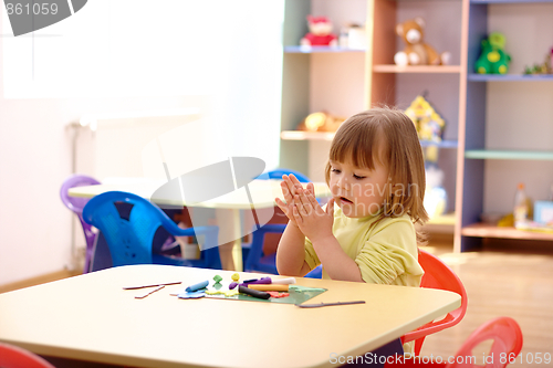 Image of Little girl play with plasticine in preschool