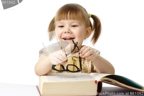 Image of Happy little girl with book wearing black glasses