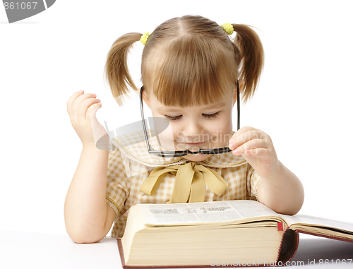 Image of Happy little girl with book wearing black glasses