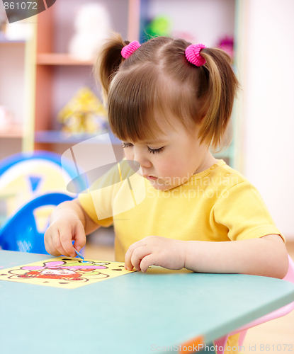 Image of Little girl coloring a picture in preschool