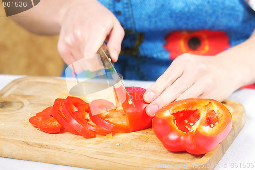 Image of Woman hands slices paprika