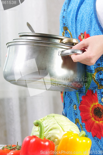 Image of Hands with pile of pans sideview