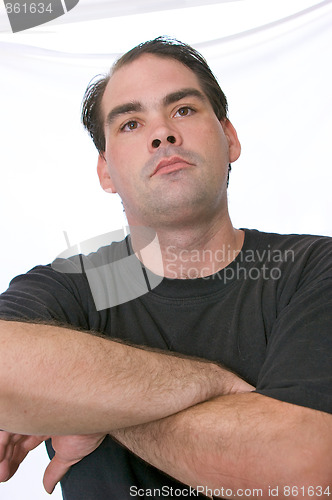 Image of looking up at man with arms crossed