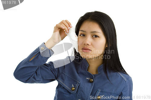 Image of young woman removing bandage from her eye