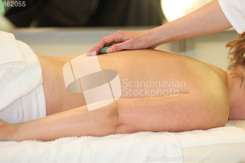 Image of A woman receives  massage with hot stones 