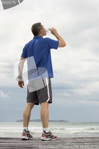 Image of Mature runner drinking water