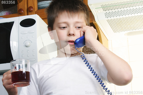 Image of Boy in white with tea talking phone