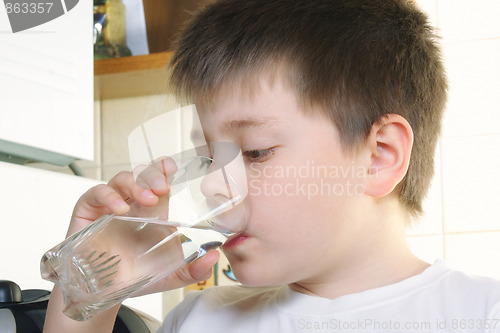 Image of Boy in white drinks water