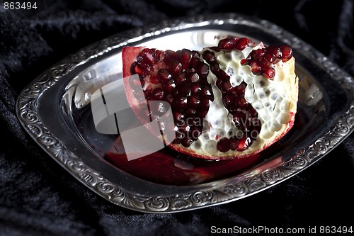 Image of Sliced Pomegranate with arils on silver plate