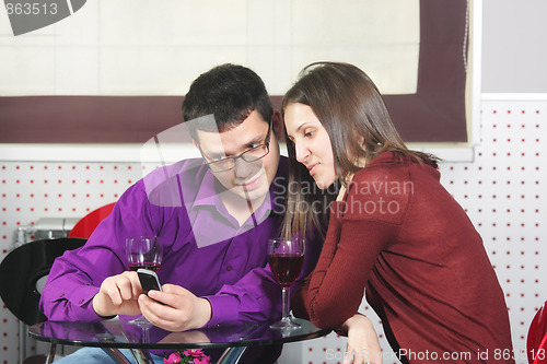 Image of Couple in cafe looking at cellphone