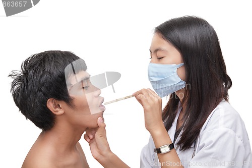 Image of Doctor examining patient throat w spatula