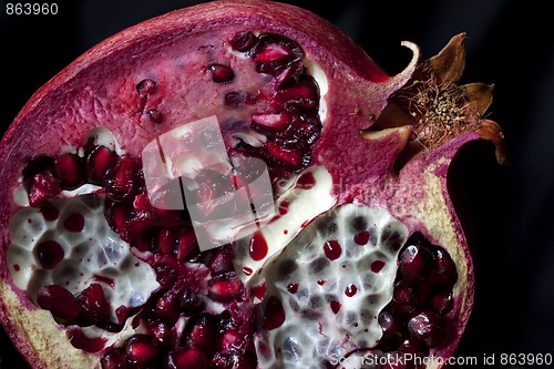 Image of Sliced Pomegranate with arils on black glass