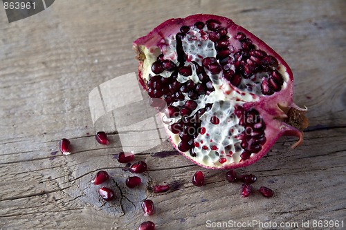 Image of Pomegranate with arils on wooden board