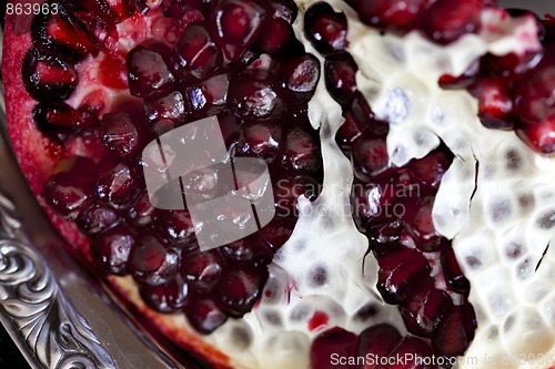 Image of Sliced Pomegranate with arils on silver plate