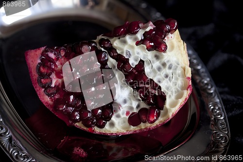 Image of Sliced Pomegranate with arils on silver plate