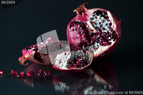 Image of Sliced Pomegranate with arils on black glass