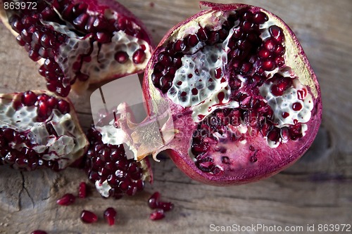 Image of Pomegranate with arils on wooden board
