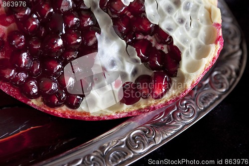 Image of Sliced Pomegranate with arils on silver plate