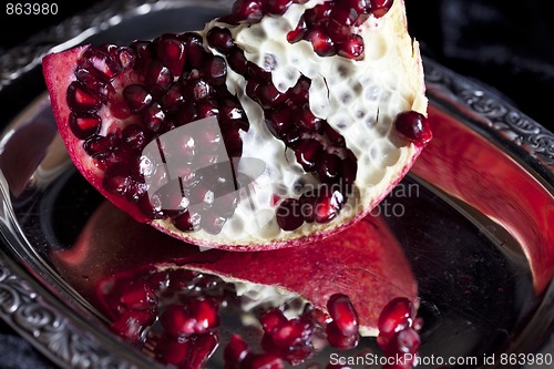 Image of Sliced Pomegranate with arils on silver plate