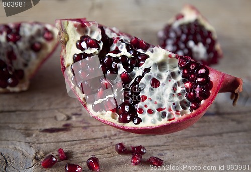 Image of Pomegranate with arils on wooden board