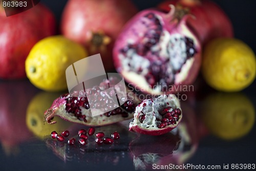 Image of Sliced Pomegranate with arils on black glass