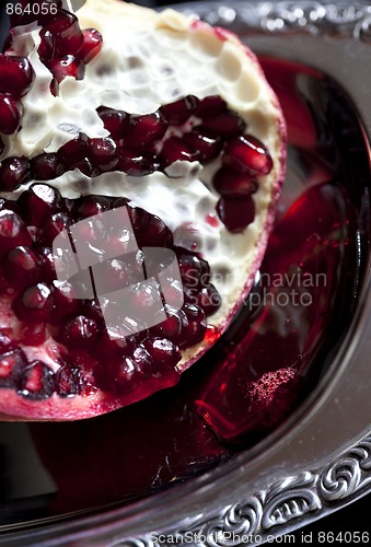 Image of Sliced Pomegranate with arils on silver plate