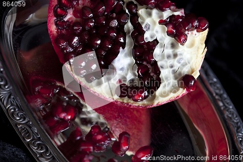 Image of Sliced Pomegranate with arils on silver plate