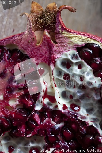 Image of Pomegranate with arils on wooden board