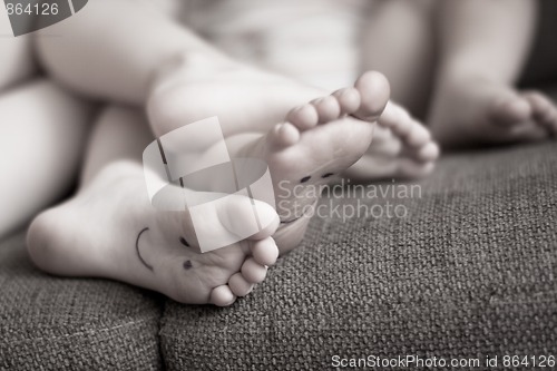 Image of Little childrens feet while relaxing on couch