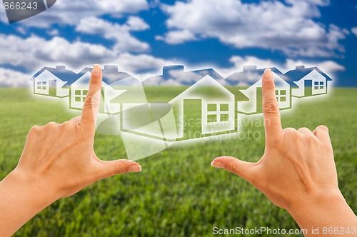 Image of Female Hands Framing Houses Over Grass and Sky