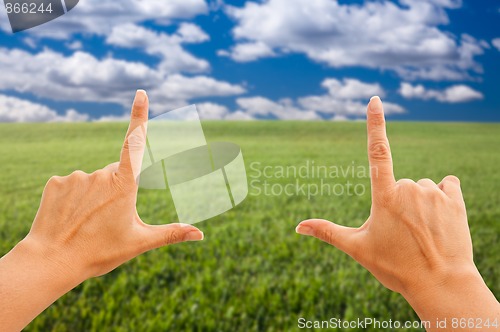 Image of Female Hands Making a Frame Over Grass and Sky