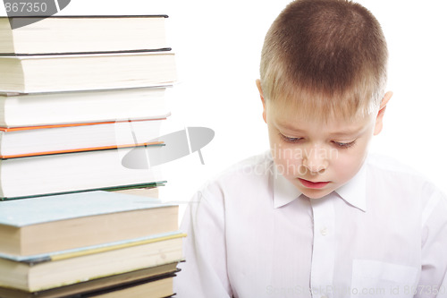 Image of Boy sitting at stack of books