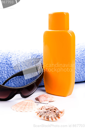 Image of towel, shells, sunglasses and lotion