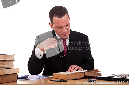Image of man on desk reading and studying