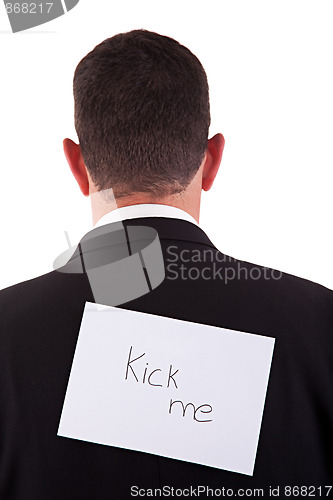 Image of back of businessman, with kick me written in a paper 