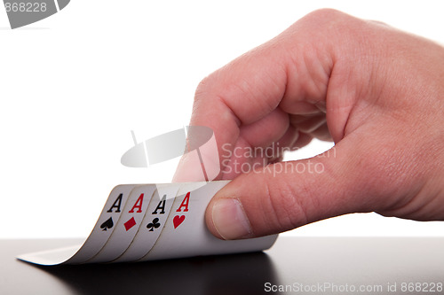 Image of man's hand revealing four aces