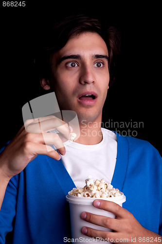 Image of young man, with popcorn watching