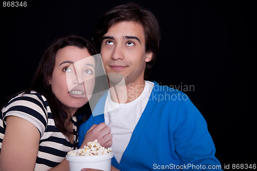 Image of couple watching tv/cinema,  with popcorn