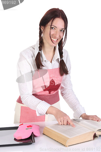 Image of housewife preparing and reading with a book recipe