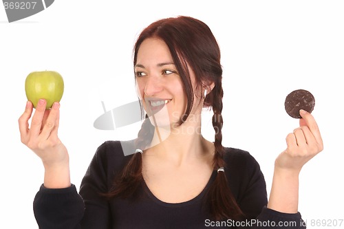 Image of woman choosing between apple and chocolate cookies