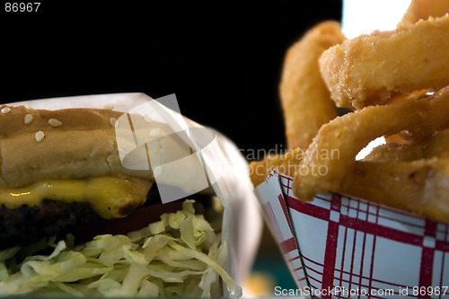 Image of Close up on Onion Rings and a Hamburger