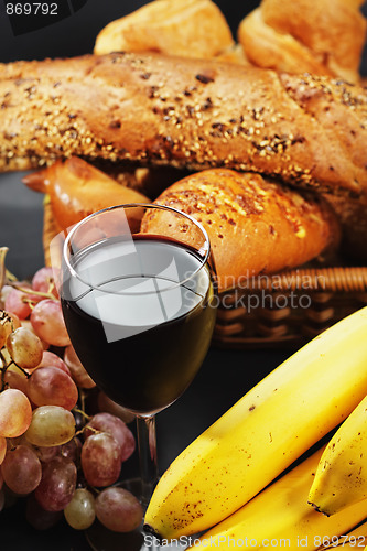 Image of Red wine among fruits and pastry