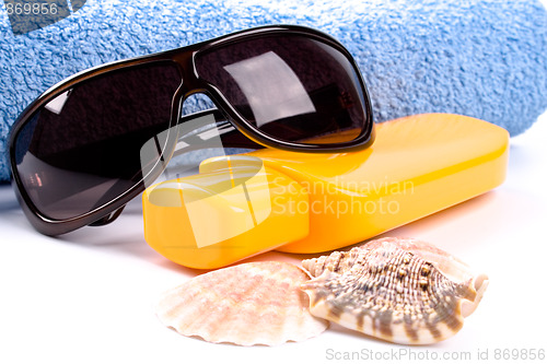 Image of towel, shells, sunglasses and lotion