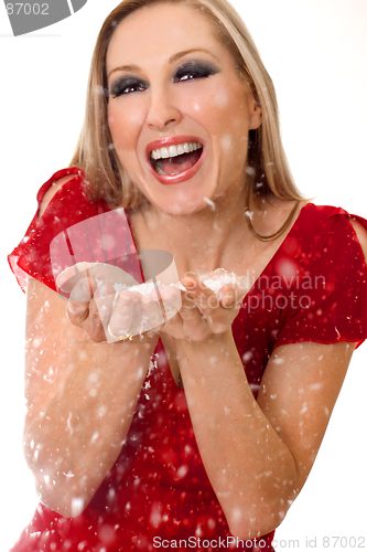 Image of Fun-loving woman blowing soft flakes