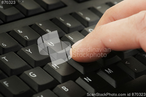 Image of finger pressing keyboard