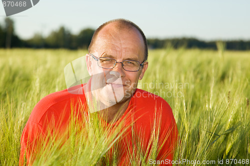 Image of Middle-aged man smiling behind hay