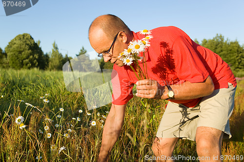 Image of Middle-aged man picking up flowers