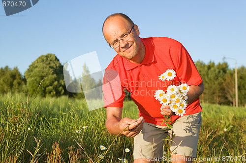 Image of Middle-aged man picking up flowers